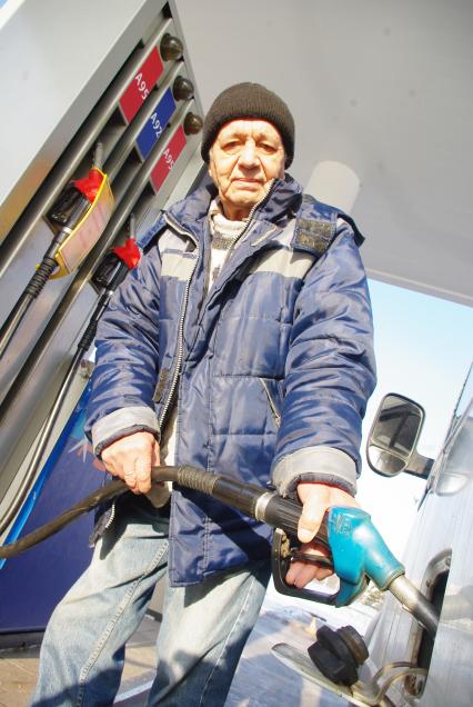 На автозаправке работник заправляет машину, Москва, 16 февраля 2011 года. Бензин, подорожание бензина, изменение цен, заправка, нефть