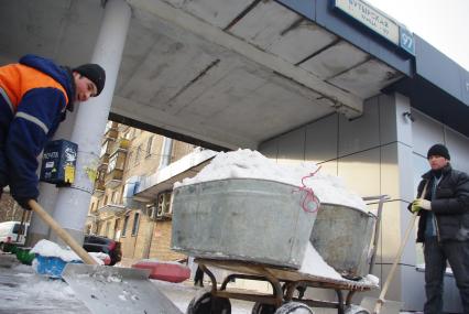 Гастарбайтеры убирают снег в корыто на тележке, Москва, 17 февраля 2011 года.