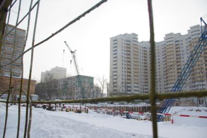На месте снесенного дома возводят новый, на заднем плане хрущевка и новые дома, Москва, 17 февраля 2011 года, метро Кузьминки. Снос домов, новое жилье, хрущевка, строительство, ипотека, затройка города