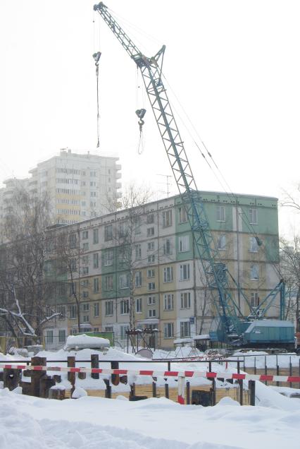 На месте снесенного дома возводят новый, на заднем плане хрущевка и новые дома, Москва, 17 февраля 2011 года, метро Кузьминки. Снос домов, новое жилье, хрущевка, строительство, ипотека, затройка города
