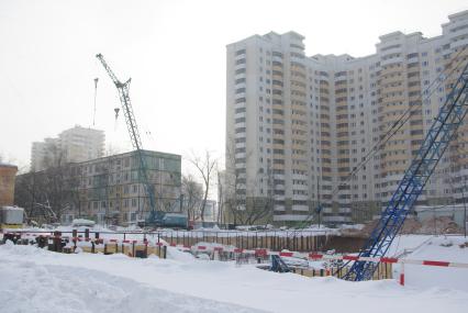 На месте снесенного дома возводят новый, на заднем плане хрущевка и новые дома, Москва, 17 февраля 2011 года, метро Кузьминки. Снос домов, новое жилье, хрущевка, строительство, ипотека, затройка города