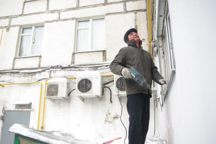 Капремонт домов в Москве. Десятки жилых домов в столице в ужасном состоянии. Их не ремонтируют, при этом треть москвичей жалуются на плохой ремонт. 
Балконы девятиэтажки разваливаются.
Ремотная бригада занимается ремонтом оконного проема в девятиэтажном доме,, Москва, 22 февраля 2011 года.