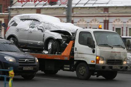 Эвакуатор везет разбитую в аварии и засыпанную снегом машину, Москва, 25 февраля 2011 года.