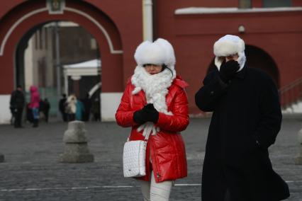 Люди спасаются от холода закутавшись в меховые шапки  и шарфы, Красная площадь, Москва, 25 февраля 2011 года.