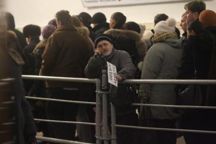 Мужчина стоит в метро с табличко \"Дипломы, аттестаты\", Москва,  25 февраля 2011 года.