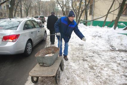 Обледеневшие дороги и дворы города посыпают реагентом и солью, Москва, 27 февраля 2011 года.