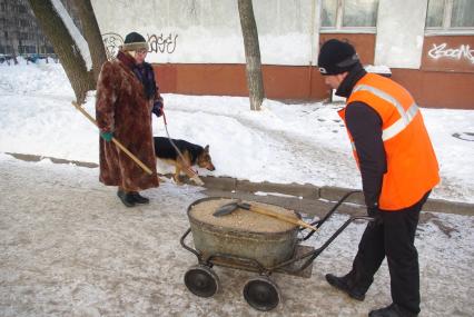 Обледеневшие дороги и дворы города посыпают реагентом и солью, Москва, 27 февраля 2011 года.