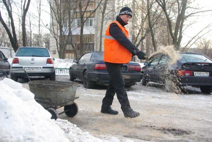 Обледеневшие дороги и дворы города посыпают реагентом и солью, Москва, 27 февраля 2011 года.