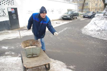 Обледеневшие дороги и дворы города посыпают реагентом и солью, Москва, 27 февраля 2011 года.