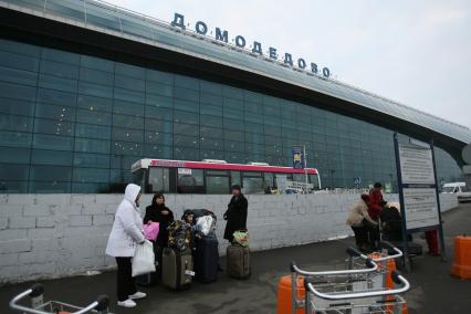 Перед аэропортом Домодедово стоят люди с чемоданами, Москва, 13 марта 2011 года