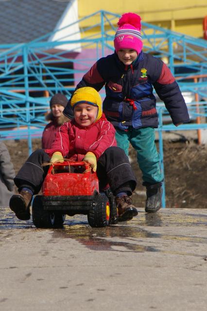 Мальчишки катаются с горки на игрушечной машине, Саратов, 23 марта 2009 года.