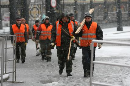 В начале апреля неожиданно выпал снег, гастарбайтеры идут на уборку города, Москва, 9 апреля 2011 года