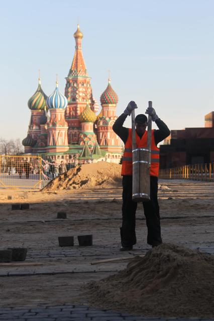 04 апреля 2011 г. Россия, Москва. Работы по ремонту и перекладка брусчатки на Красной площади.  На заднем плане Храм Василия Блаженного.