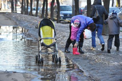 04 апреля 2011 г. Россия, Москва. Дети и их родители. лужа на тротуаре