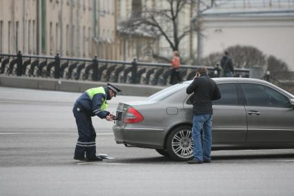 Полицейский скручивает с машины номера 222, Москва, 17 апреля 2011 года