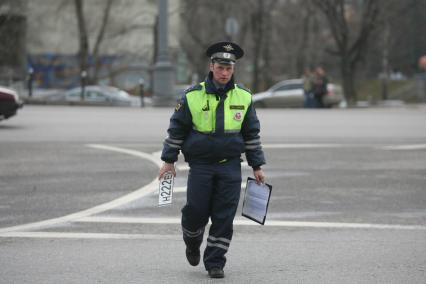 Полицейский скручивает с машины номера 222, Москва, 17 апреля 2011 года