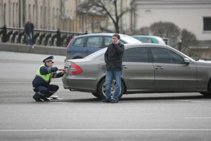 Полицейский скручивает с машины номера 222, Москва, 17 апреля 2011 года