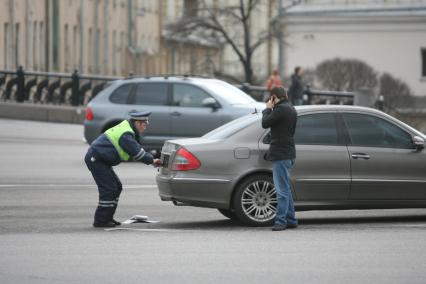 Полицейский скручивает с машины номера 222, Москва, 17 апреля 2011 года