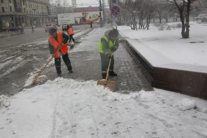 Россия. Москва. 09 апреля 2011г. Гастарбайтер, уборка снега.