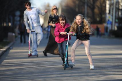 Две девочки на самокате в парке ВДНХ, Москва, 24 апреля 2011 года