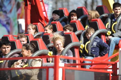 Горожане катаются на аттракционах в парке ВДНХ, Москва, 24 апреля 2011 года