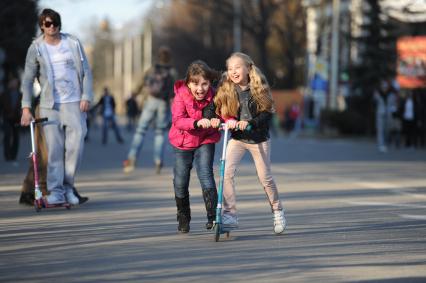 Две девочки на самокате в парке ВДНХ, Москва, 24 апреля 2011 года