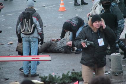 Митинг на Манежной площади, который начался в память о погибшем болельщике СПАРТАКА Егоре Свиридове и перерос в массовые беспорядки и погром. На снимке: На асфальте лежит пострадавщий. 11 декабря 2010 года.