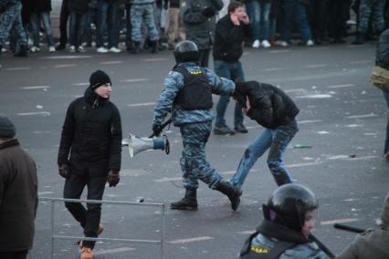 Митинг на Манежной площади, который начался в память о погибшем болельщике СПАРТАКА Егоре Свиридове и перерос в массовые беспорядки и погром. На снимке: Сотрудник ОМОНа ведет одного из митингующих. 11 декабря 2010 года.