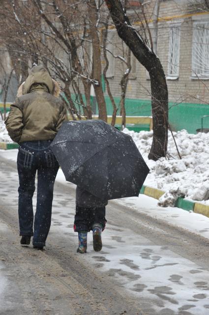 12 апреля 2011г. Москва. Снег, лужи, слякоть.  Женщина с ребенком.