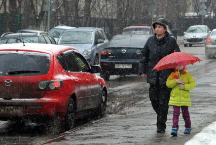 12 апреля 2011г. Москва. Снег, лужи, слякоть.  Женщина с ребенком.