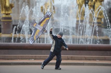 Мальчик запускает воздушного змея у фонтана в парке ВДНХ, Москва, 2 мая 2011 года