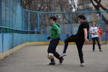 Мальчишки играют в футбол в дворовой команде, Москва, 19 апреля 2011 года