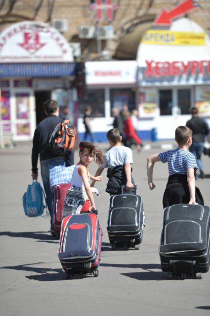 Семья тащит чемоданы у Ленинградского вокзала, Москва, 11 мая 2011 года