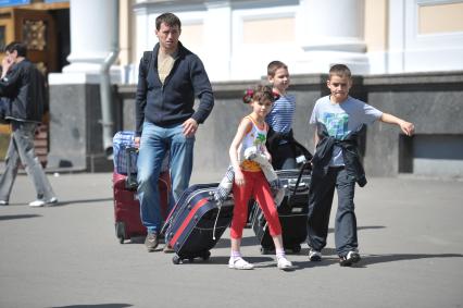 Семья тащит чемоданы у Ленинградского вокзала, Москва, 11 мая 2011 года