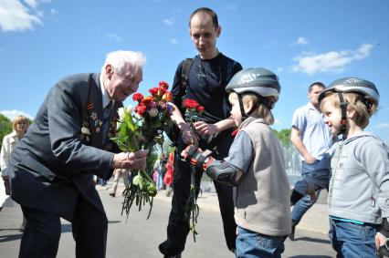 Ветеранам дарят цветы на празднование Дня Победы в ЦПКиО им. Горького, Москва, 9 мая 2011 года