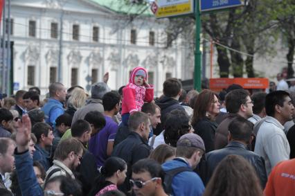 Девочка сидит на плечах отца и испуганно смотрит на толпу людей, выхолдящих из метро, Москва, 9 мая 2011 года