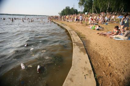 Лето. Купание. Городской пляж. Мусор в воде.