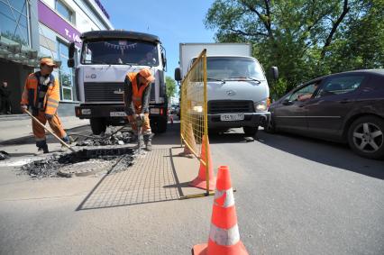 Гастарбайтеры ремонтируют дорогу вскрывают асфальт, Москва, 20 мая 2011 года