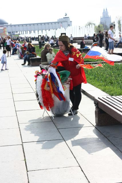 09 мая 2011г. Москва. Поклонная гора. Праздник. Девушка продает флаги, солдатские пилотки.