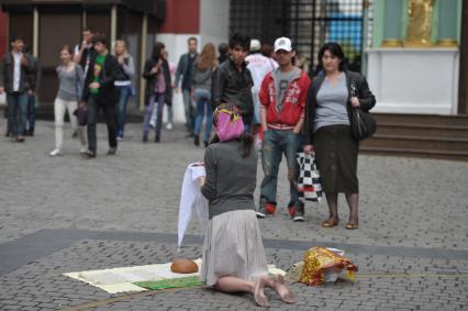 На манежной площади девушка стоит на коленях и молится, Москва, 8 мая 2011 года