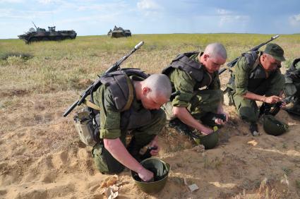 Армия. Учения. Военная подготовка. полигон. Боевая техника. На снимке: Солдаты заполняют магазин автомата патронами.  24 мая 2011 г.