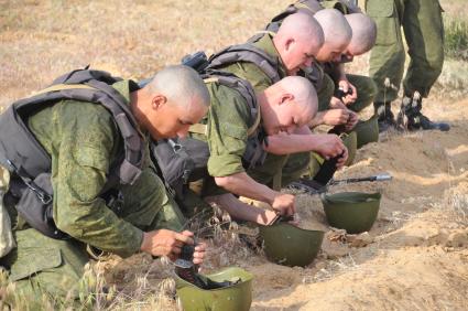 Учения. Военная подготовка. Солдаты наполняю магазин автомата патронами. 24 мая 2011 г.