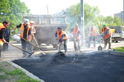 Гастарбайтеры кладут асфальт на пешеходную дорожку, Москва, 21 мая 2011 года