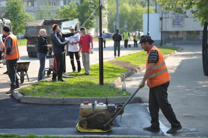 Гастарбайтеры кладут асфальт на пешеходную дорожку, Москва, 21 мая 2011 года