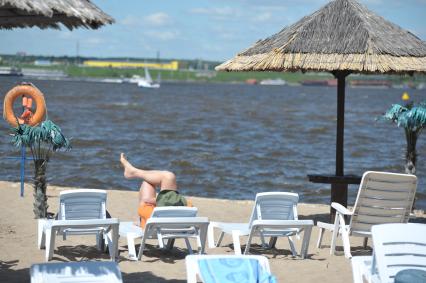 Мужчина лежит на шезлонге и смотрит на воду, Москва, 5 июня 2011 года