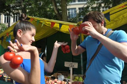 Молодой человек и девушка с помидорами в руках,  Москва,10 июня 2011 года