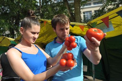 Молодой человек и девушка с помидорами в руках, Москва,10 июня 2011 года
