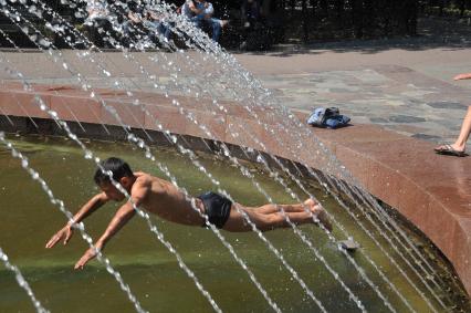 Молодой человек прыгает в фонтан раздетый до трусов. 2 июня 2011 года.