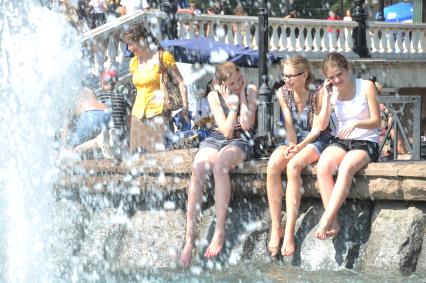 Молодые девушки сидят у фонтана. Общаются. 2 июня 2011 года.