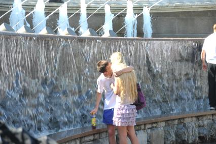 Молодой человек у фонтана обнимает и целует девушку. 2 июня 2011 года.